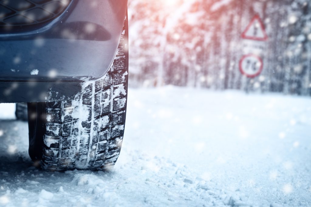Close-up of a winter tire on a snowy road