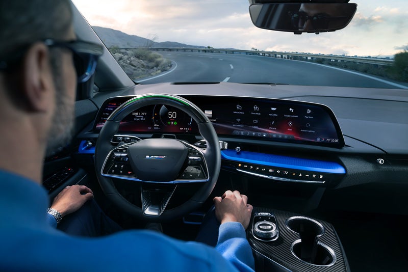 Front View of the 2026 OPTIQ-V Driving Through the Dusk Utilizing its Headlights | Fitzgerald Cadillac of Hagerstown in Hagerstown MD