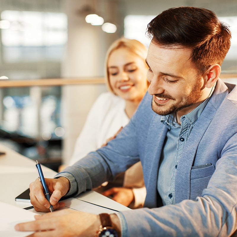 couple finalizing paperwork for their new Escalade from Fitzgerald Cadillac of Hagerstown in Hagerstown MD 