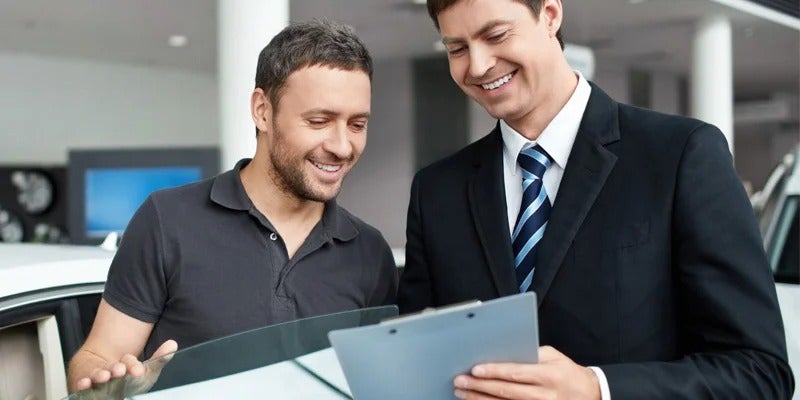 sales rep going over paperwork with customer from Fitzgerald Cadillac of Hagerstown in Hagerstown MD 